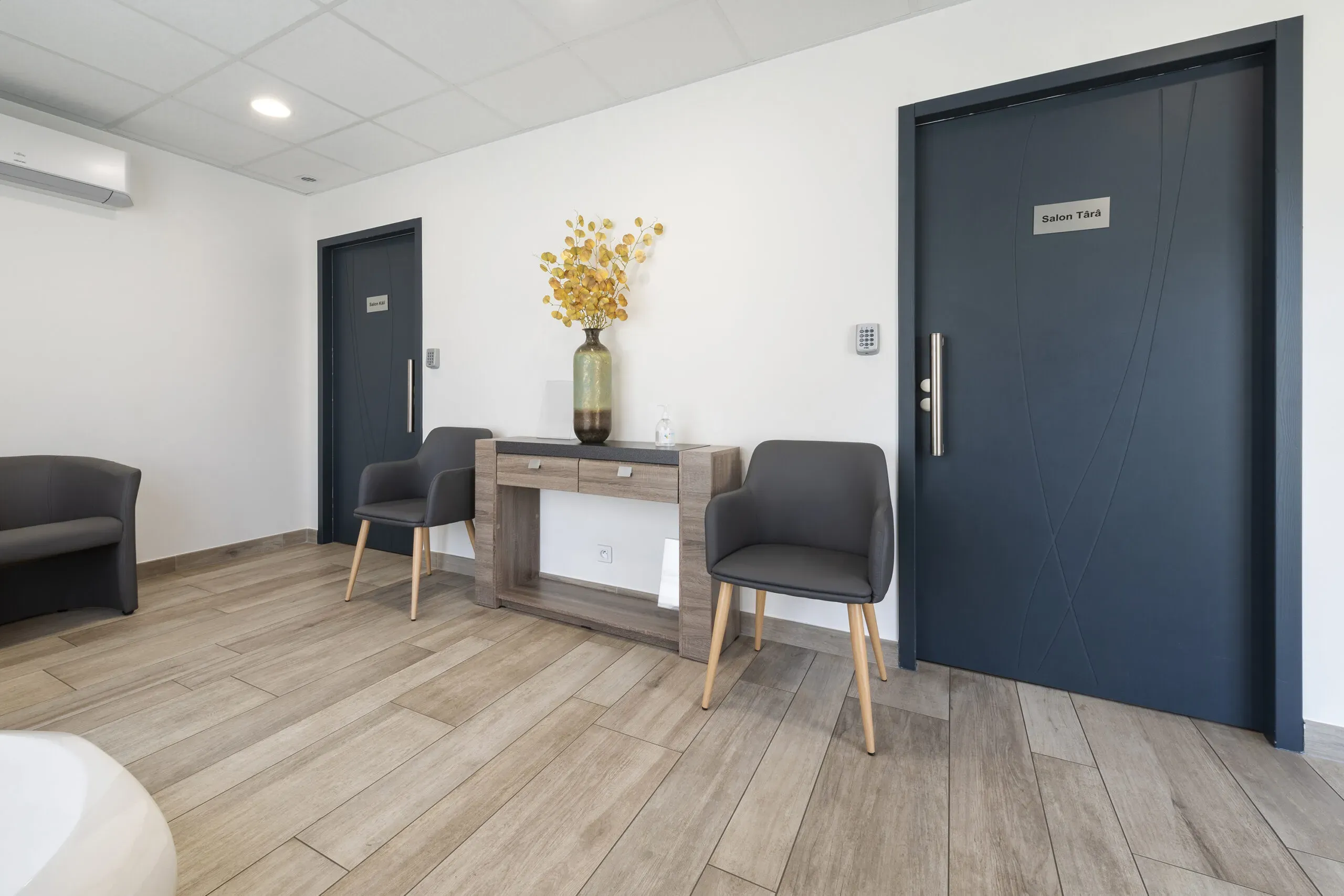 Salle d'attente avec fauteuils et portes des salons funéraires.