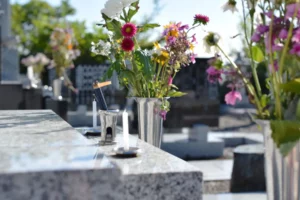 Vases de fleurs fraîches et bougies sur une tombe en marbre.